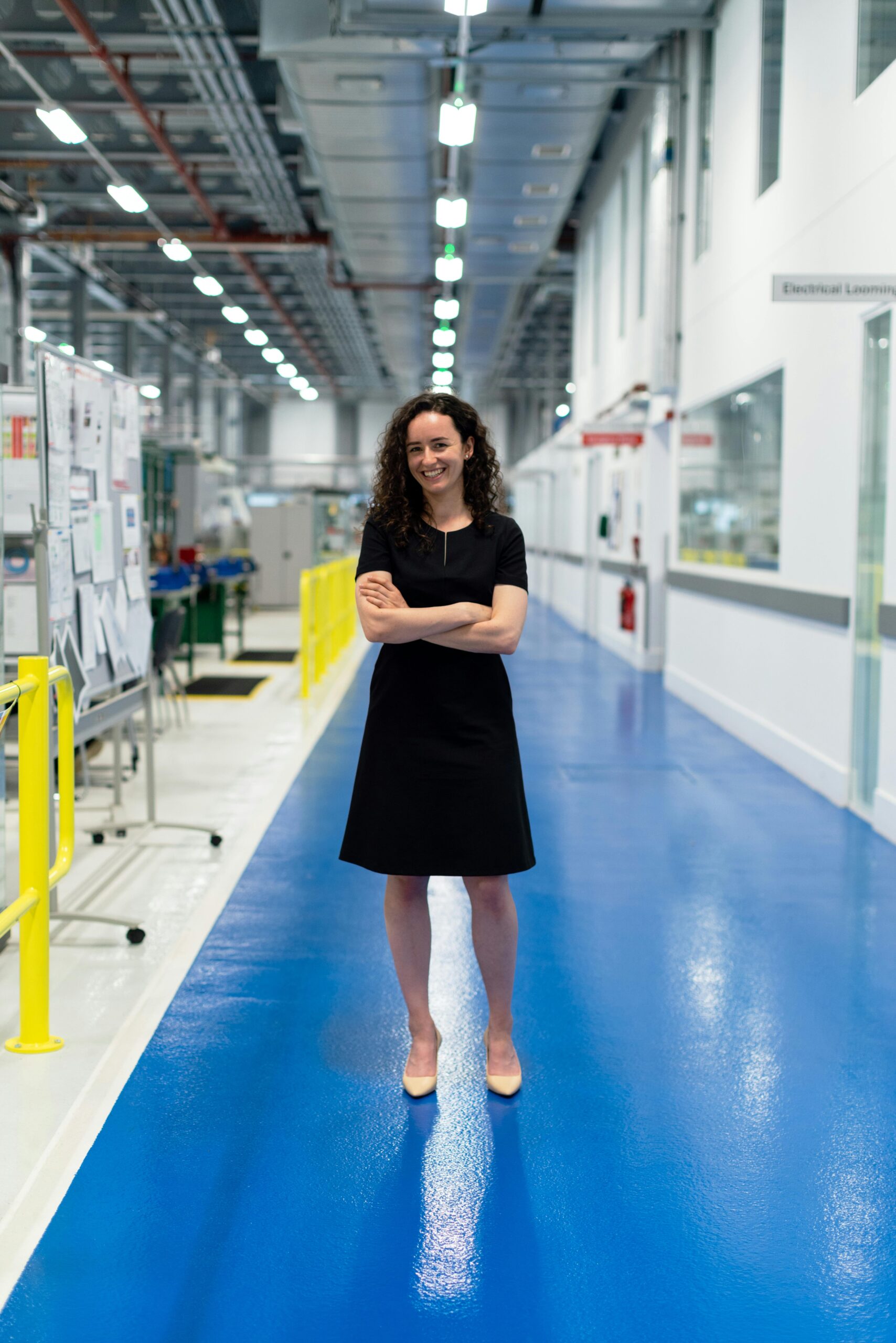 Confident female engineer standing in a high-tech industrial facility, showcasing engineering profession.
